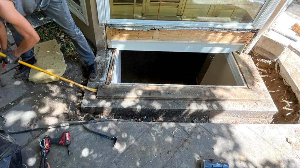 A technician removes wood from the top of the footing.