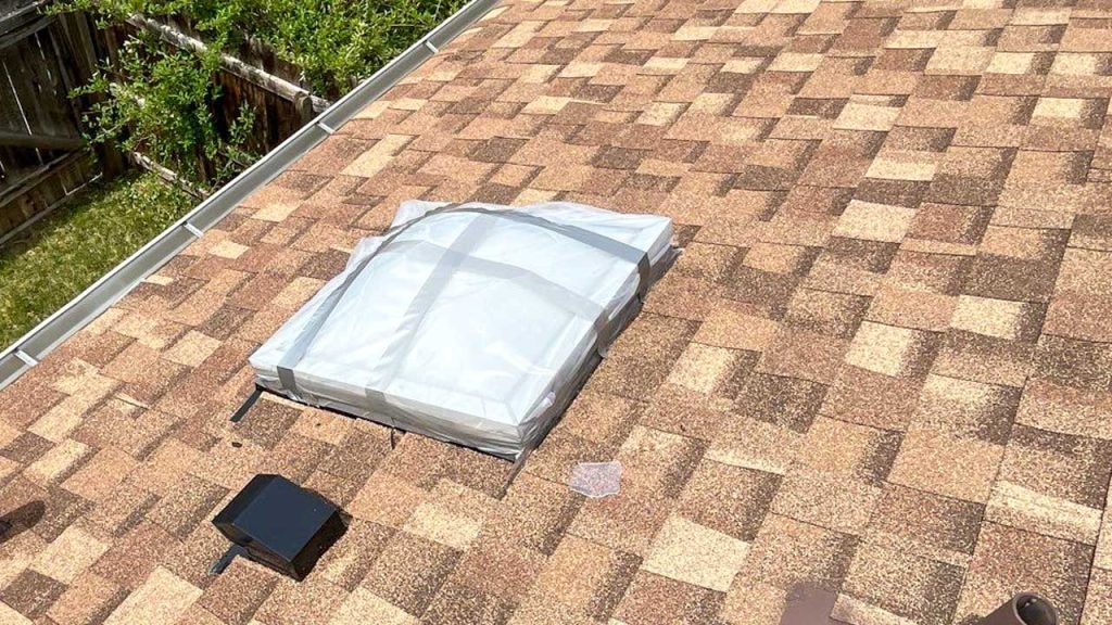 An image showing a hail damaged skylight after an emergency cover.