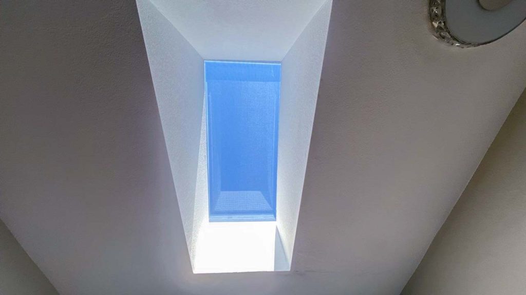 A clear sky view through the bathroom skylight.