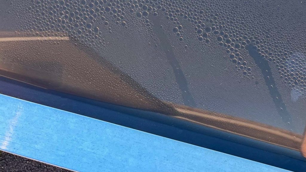 An image of water droplets between the two acrylic layers of the problem skylight.