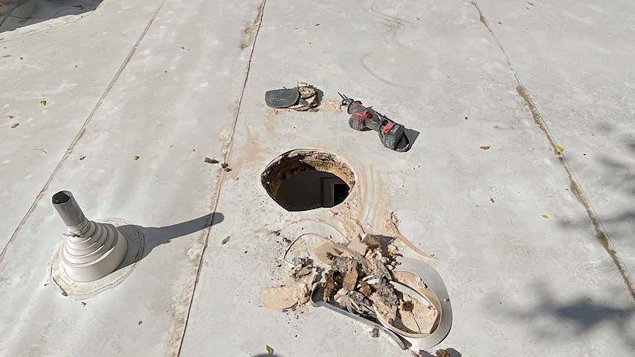 An image of a round opening cut in a flat roof for the Sun Tunnel installation.