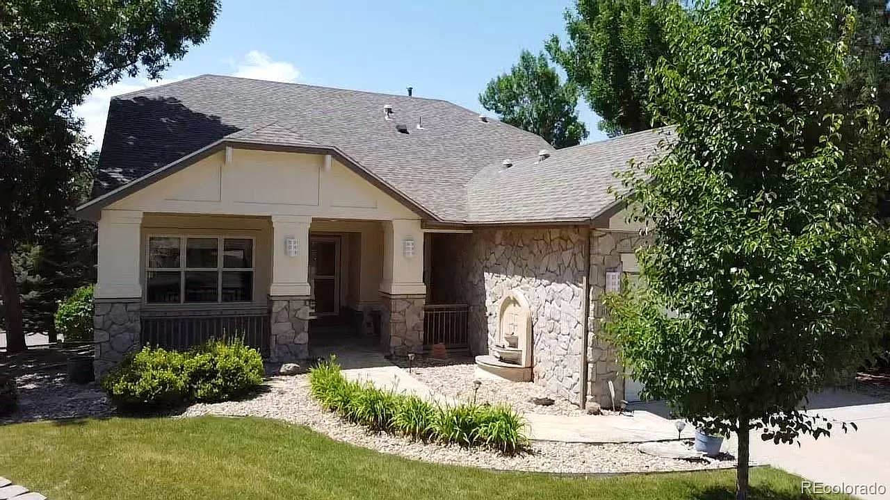 A spacious home featuring a large driveway and expansive yard, surrounded by greenery.