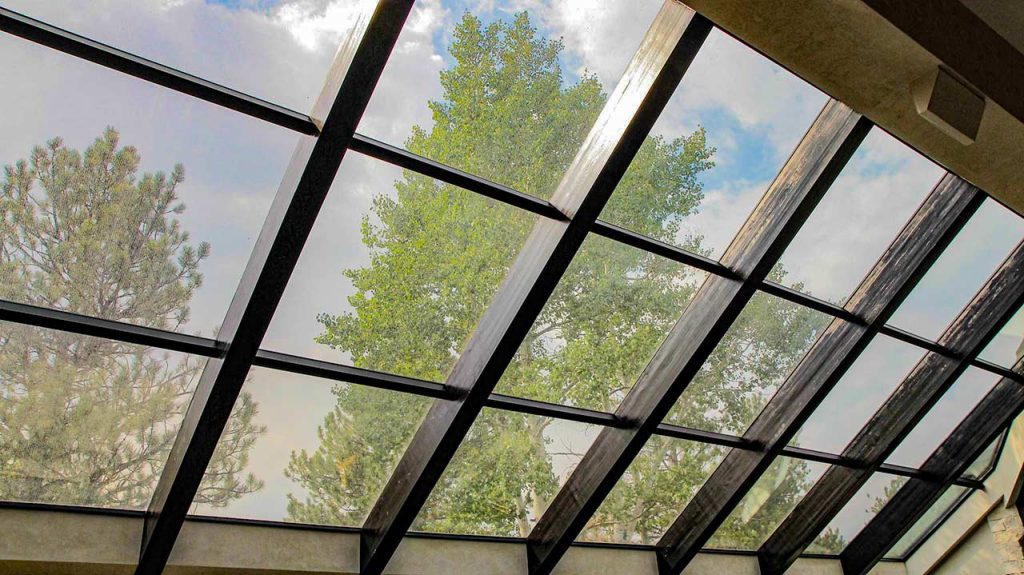 Looking through the new glazing system at trees and the sky.