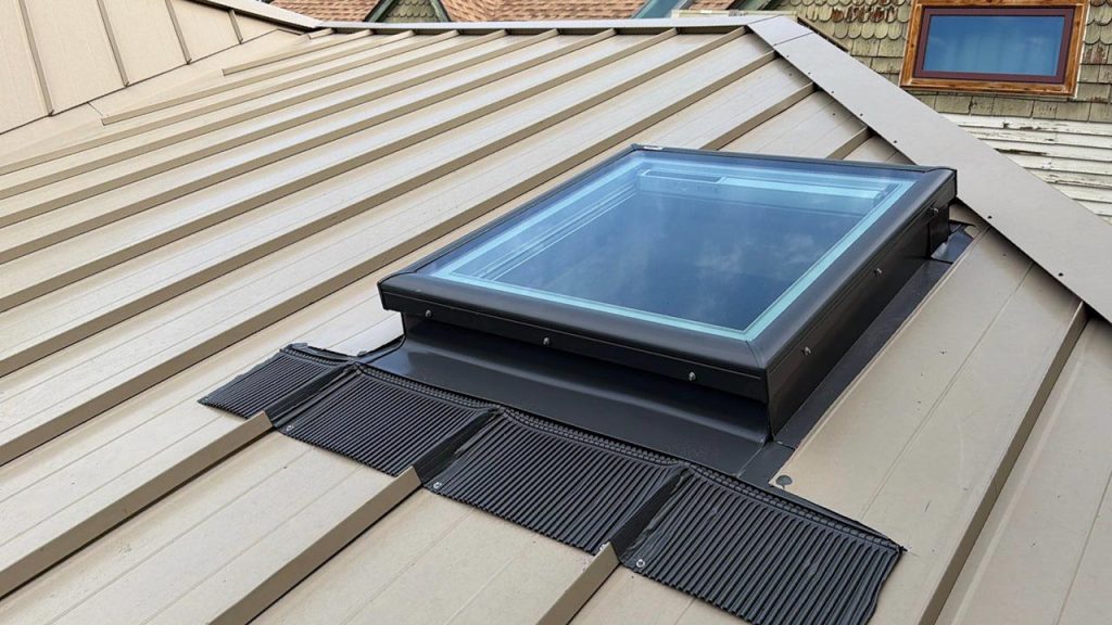 Exterior view of a newly installed VELUX FCM 3030 fixed curb-mounted skylight on a metal roof.