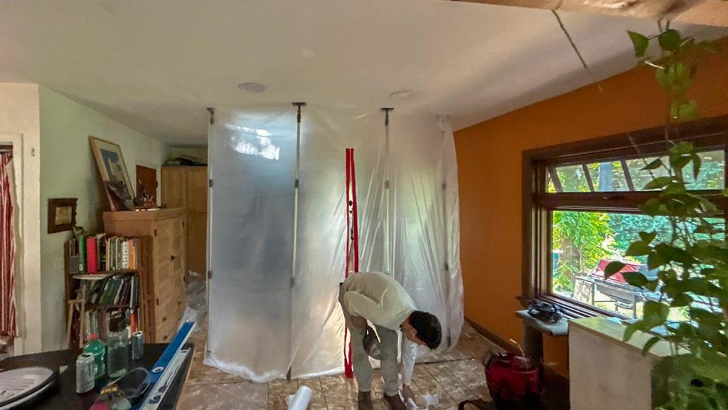 Plastic containment barrier and dust containment system set up inside a home during VELUX FCM 3030 skylight shaft construction.